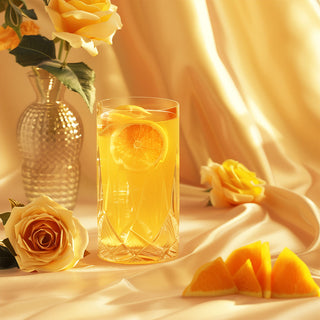 Skin LDN Collagen Beauty Drink in Mango and Orange flavor in a vintage glass, surrounded by fresh mango slices and orange segments, with a luxurious satin backdrop, showcasing a vibrant and elegant presentation designed to enhance skin health.